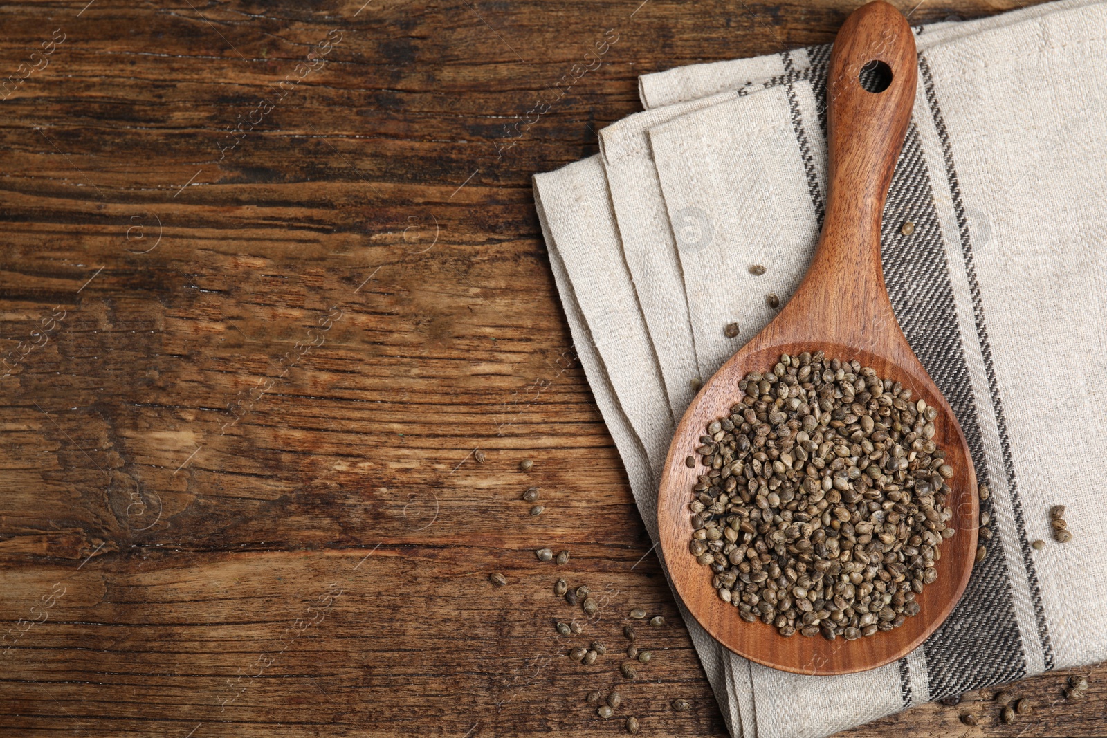 Photo of Wooden spoon with organic hemp seeds on table, flat lay. Space for text