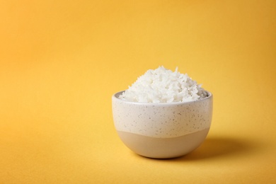 Photo of Bowl of boiled rice on color background. Space for text