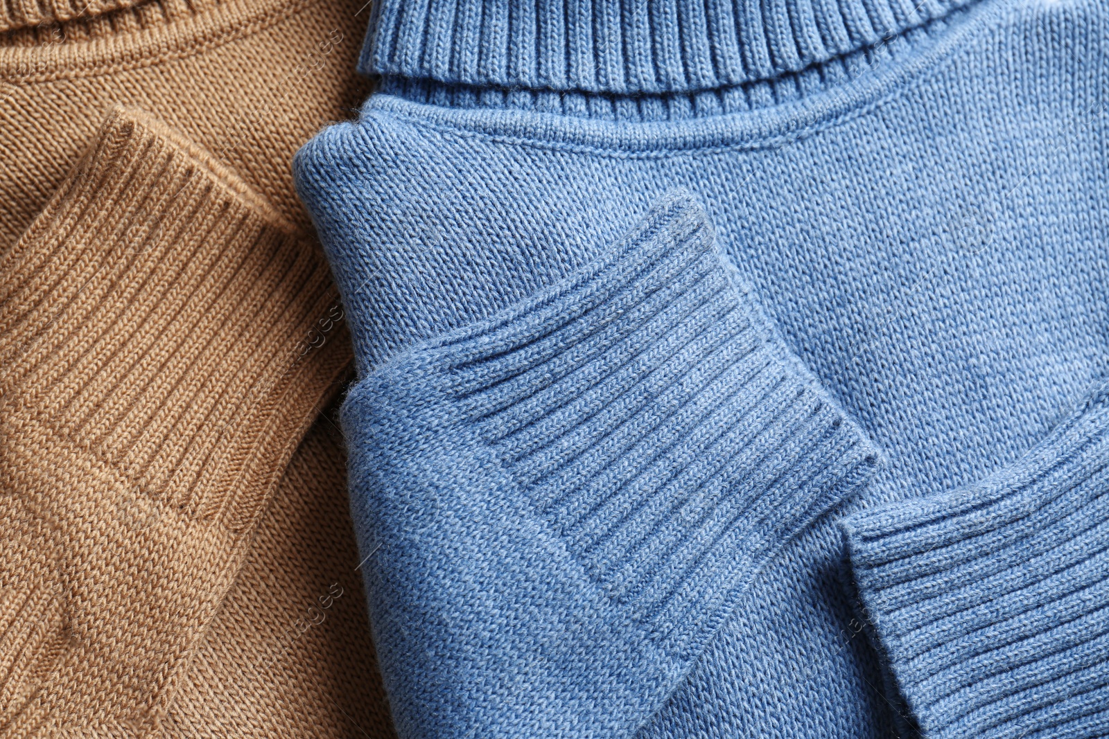 Photo of Soft stylish knitted sweaters as background, closeup