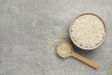 Photo of Different sorts of rice on grey table, flat lay. Space for text