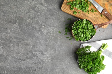 Photo of Flat lay composition with fresh green parsley on grey table, space for text