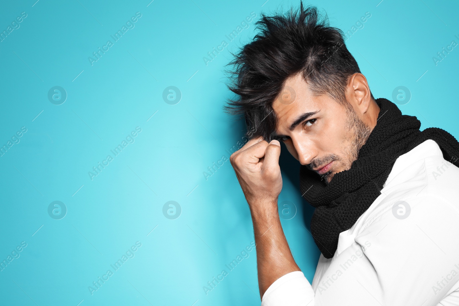 Photo of Young man with trendy hairstyle posing on color background