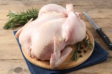 Fresh raw chicken with spices and knife on wooden table