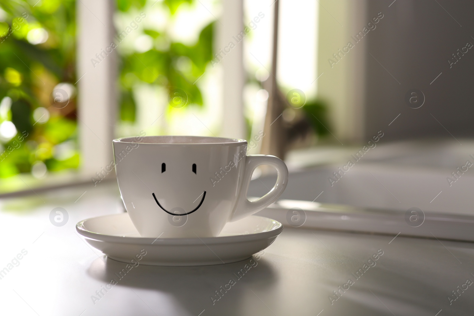 Image of Good morning. Delicious coffee in cup with happy face on kitchen countertop, space for text. 