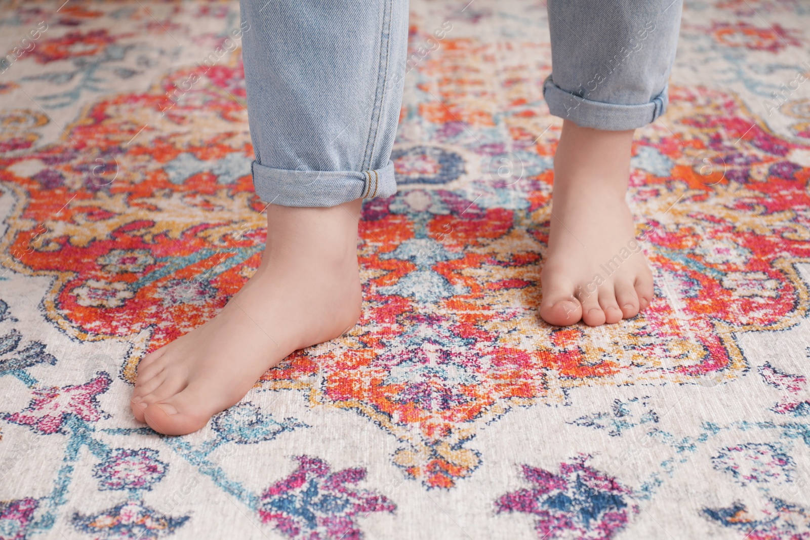 Photo of Woman standing on carpet with pattern, closeup