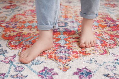 Woman standing on carpet with pattern, closeup