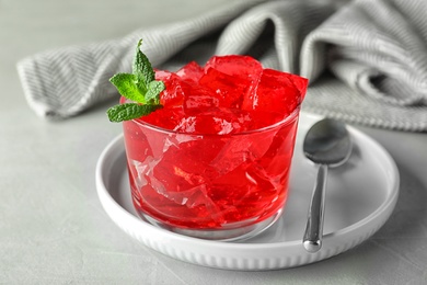 Photo of Delicious red jelly in glass on light table