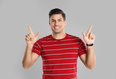 Man showing number four with his hands on grey background