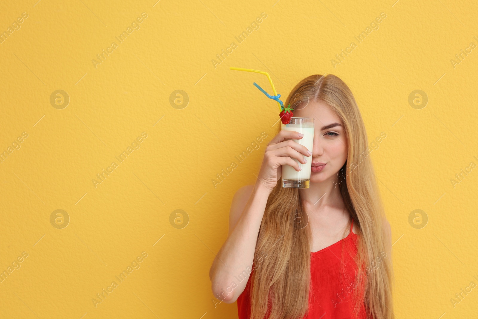 Photo of Young woman with glass of delicious milk shake on color background