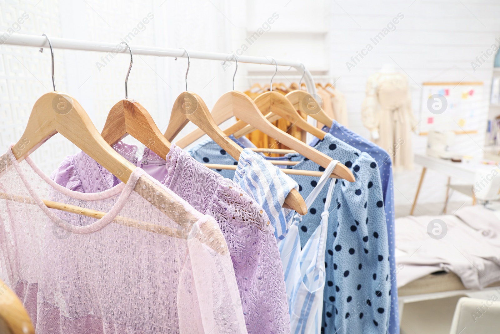 Photo of Collection of stylish female clothes in dressmaking workshop