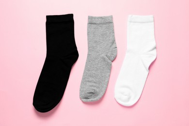 Photo of Different socks on pink background, flat lay