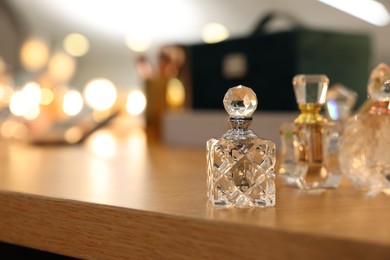 Photo of Beautiful perfume bottle on wooden table, space for text