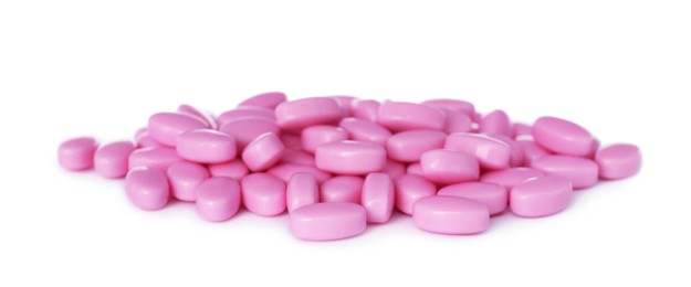 Tasty pink dragee candies on white background