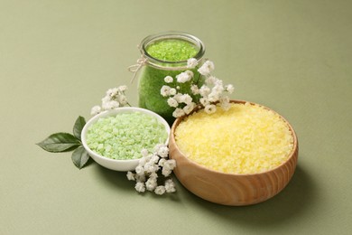 Photo of Sea salt and beautiful flowers on olive background