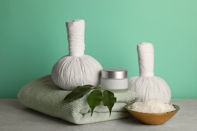 Composition with different spa products on beige table against turquoise background