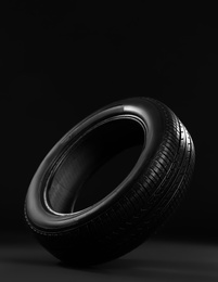Photo of New car tire on black background