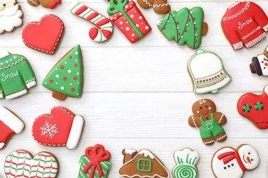 Frame of different delicious Christmas cookies on white wooden table, flat lay. Space for text