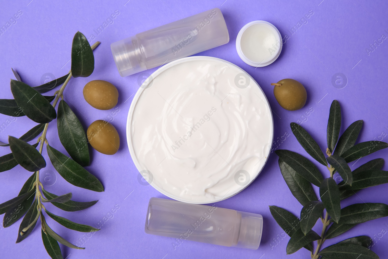 Photo of Different cosmetic products and olives on violet background, flat lay