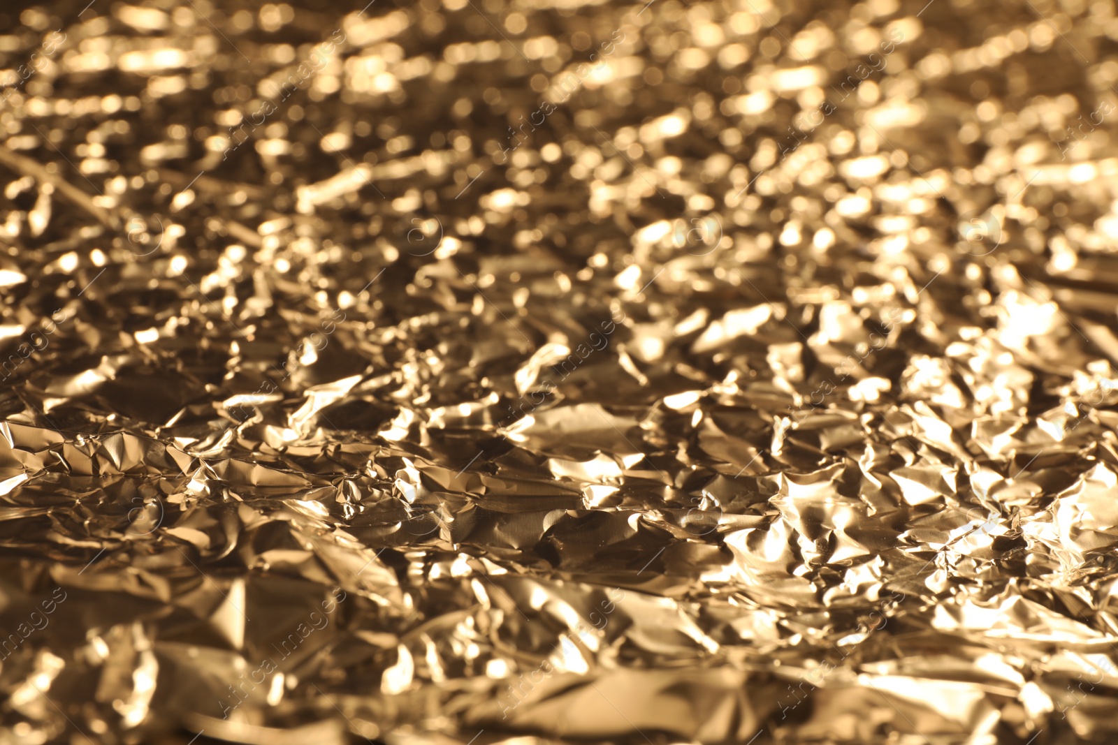 Photo of Crumpled gold foil as background, closeup view