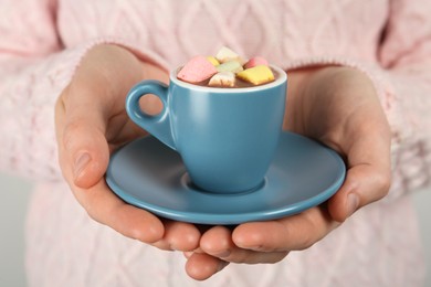 Woman holding cup of delicious hot chocolate with marshmallows, closeup