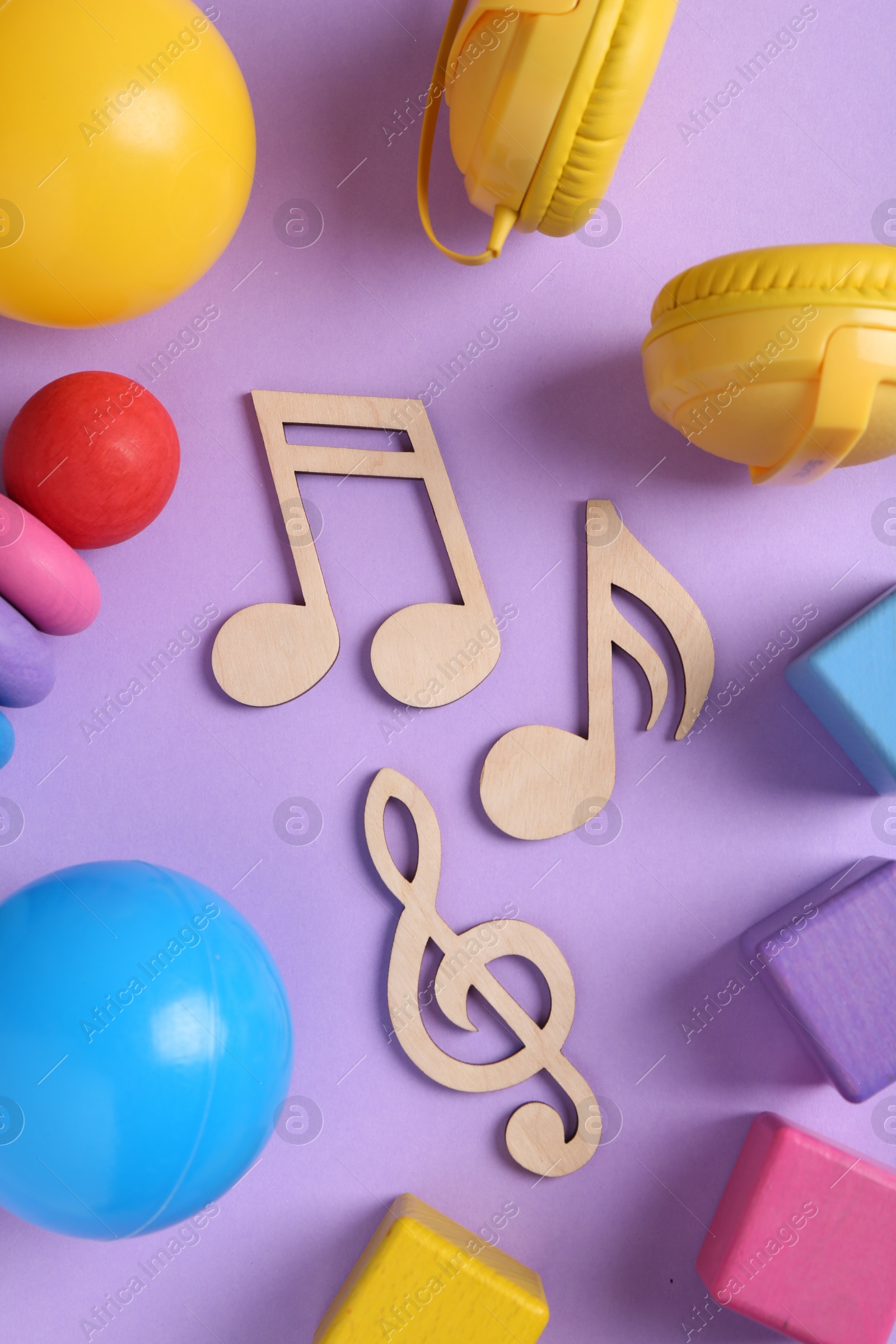 Photo of Tools for creating baby songs. Flat lay composition with wooden notes on violet background