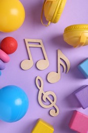 Tools for creating baby songs. Flat lay composition with wooden notes on violet background