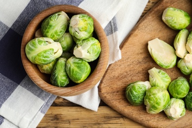 Photo of Fresh Brussels sprouts on wooden table, flat lay