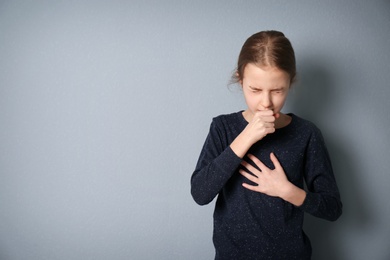 Photo of Girl coughing on grey background
