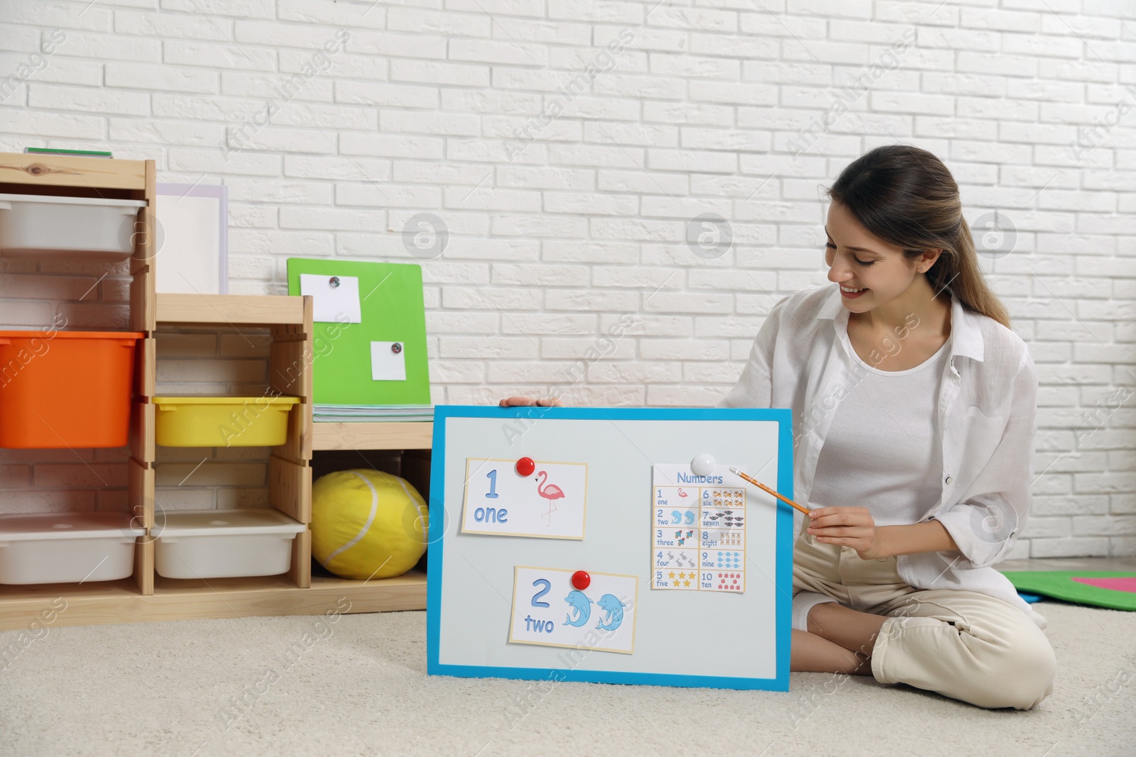 Photo of Happy female English teacher giving lesson in elementary school