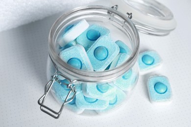 Photo of Jar with water softener tablets on white table, closeup