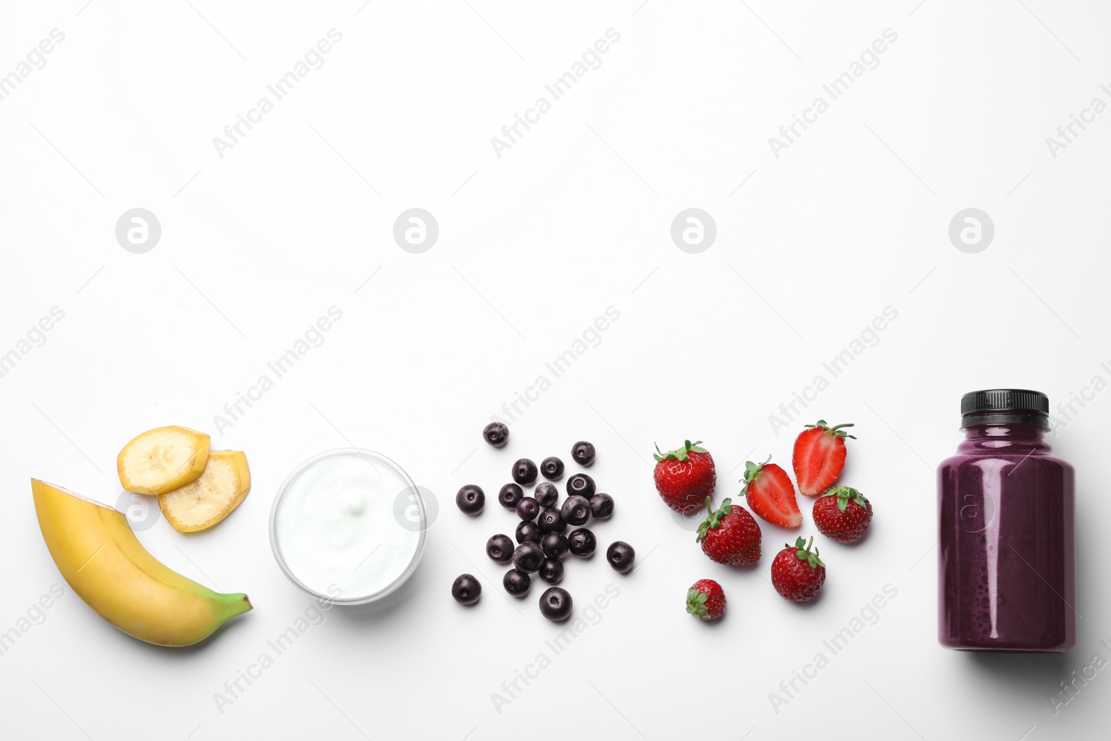 Photo of Bottle of acai drink and ingredients on white background, top view