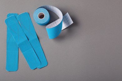 Photo of Bright kinesio tape on grey background, flat lay. Space for text