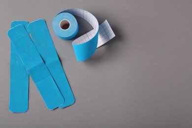 Bright kinesio tape on grey background, flat lay. Space for text