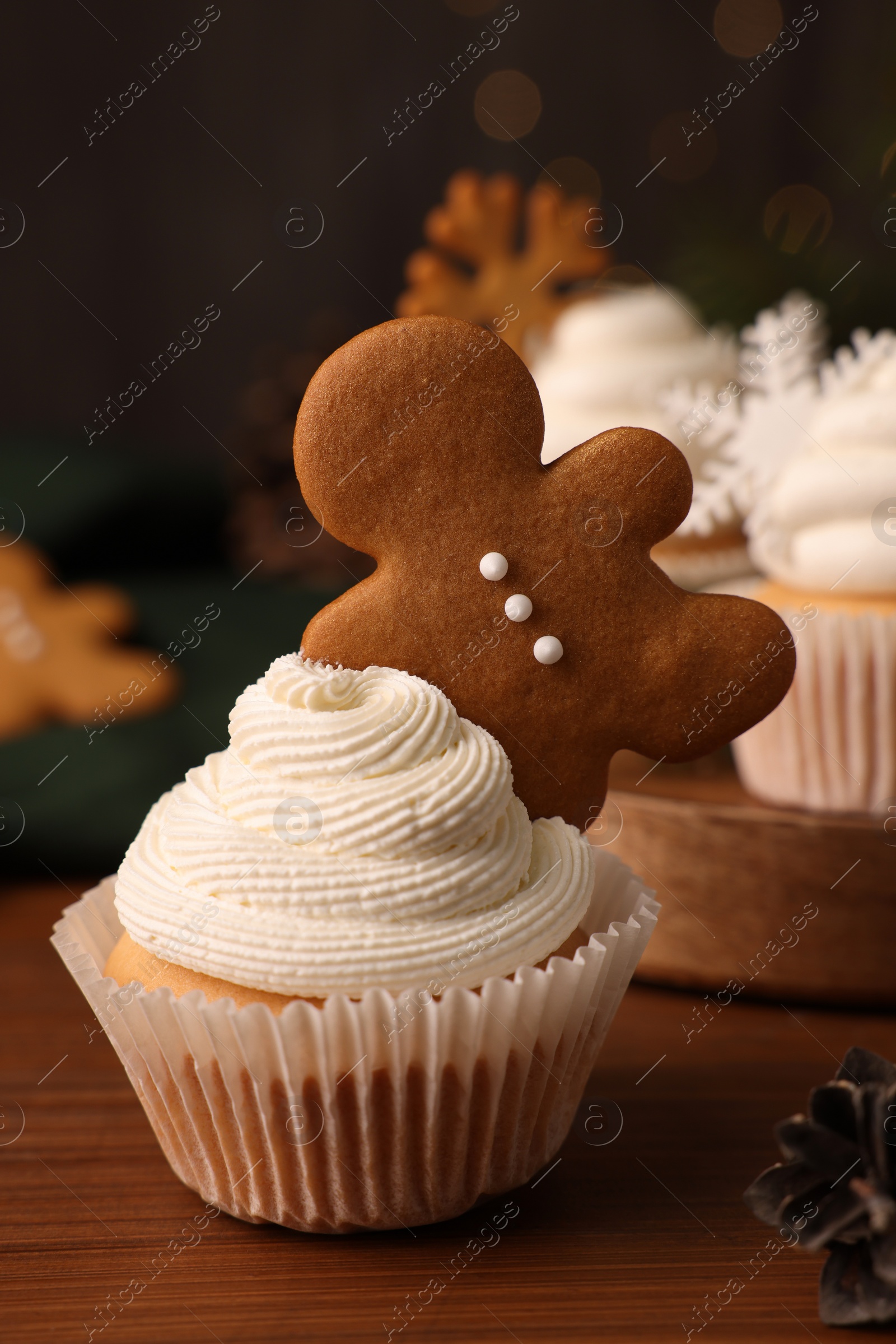 Photo of Tasty Christmas cupcake with gingerbread man on wooden table