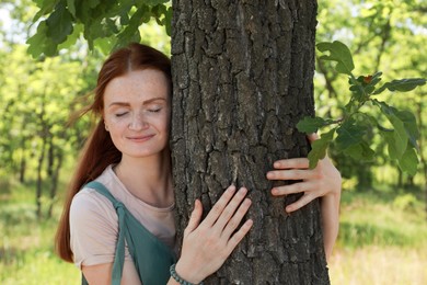 Photo of Beautiful woman hugging tree trunk in forest