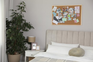 Photo of Stylish room interior with comfortable bed and vision board on wall