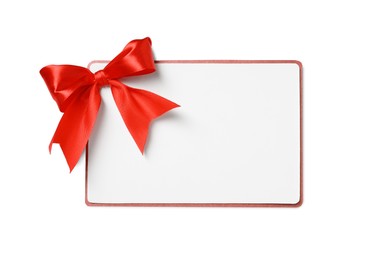 Blank gift card with red bow isolated on white, top view