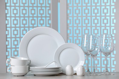 Photo of Set of clean dishware on light grey table