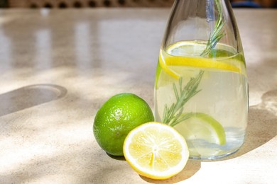 Photo of Tasty refreshing lemonade and ingredients on light table, space for text. Summer drink