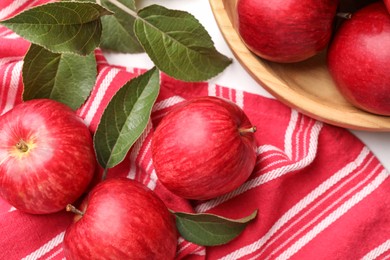 Photo of Fresh red apples with leaves on white table, flat lay