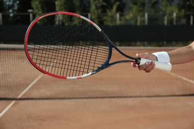 Sportswoman playing tennis at court on sunny day, closeup