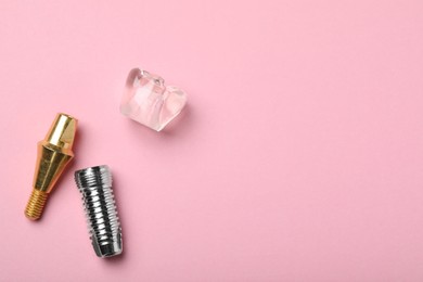 Parts of dental implant on pink background, flat lay. Space for text