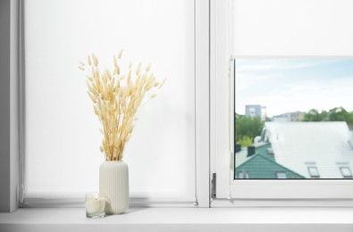 Window with blinds and dry plants on sill indoors