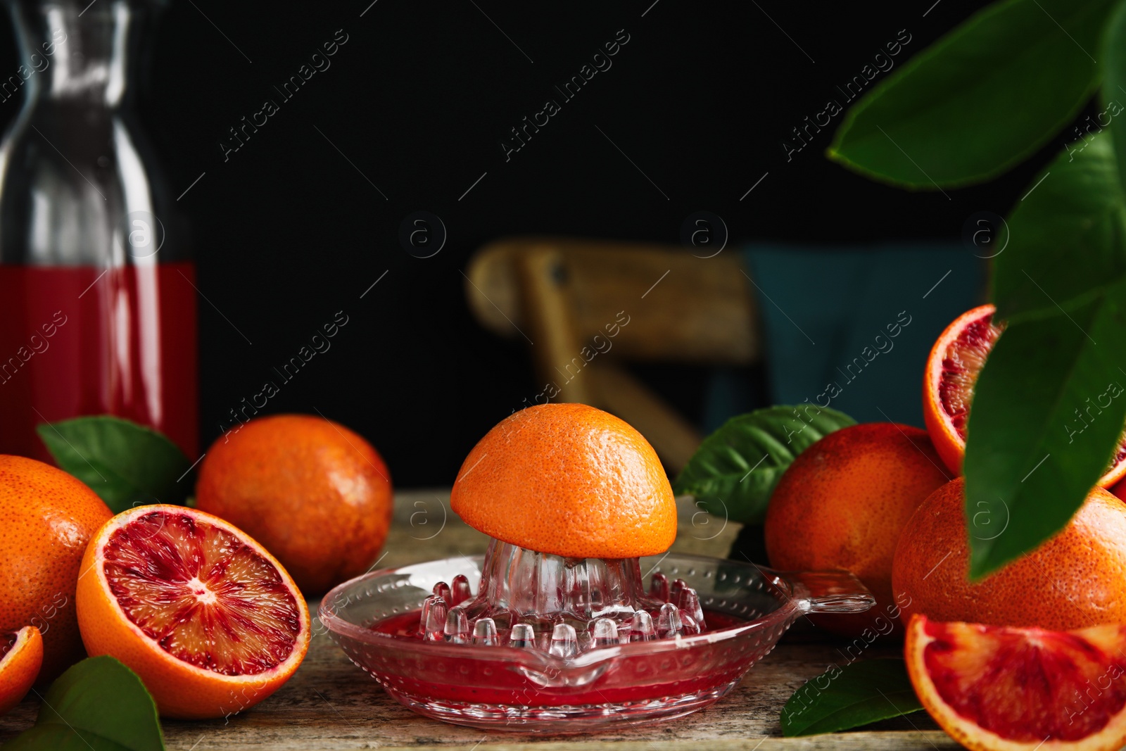 Photo of Squeezer with half of sicilian orange on wooden table, space for text