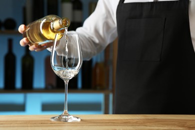 Photo of Bartender pouring wine into glass at counter in restaurant, closeup