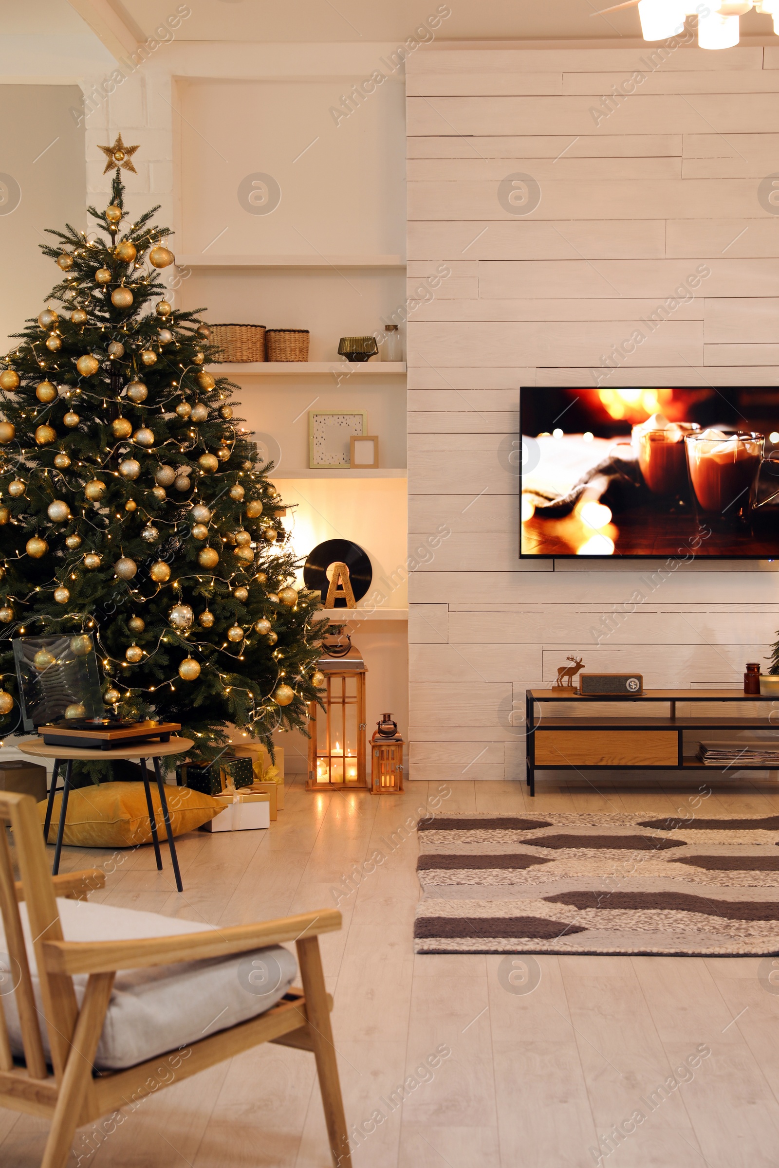 Photo of Plasma TV on white wooden wall in living room beautifully decorated for Christmas