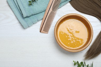 Flat lay composition with homemade hair mask in bowl on white wooden table, space for text