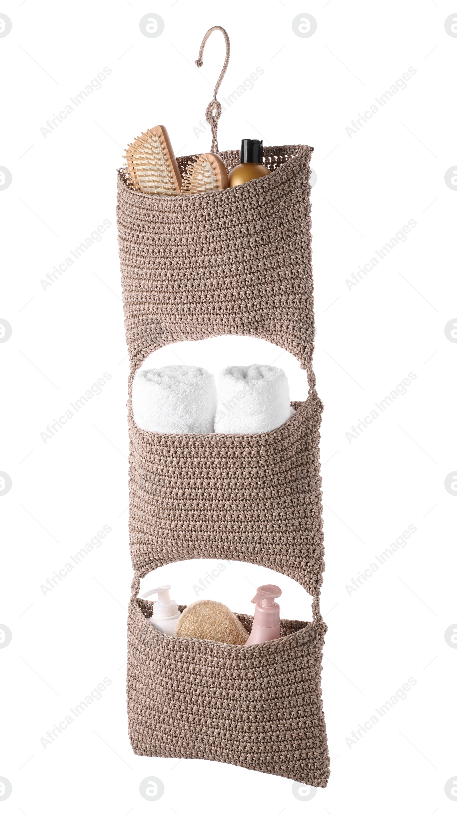 Photo of Stylish knitted organizer with toiletries and towels on white background. Bath accessory