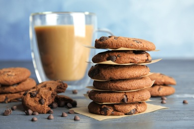 Tasty chocolate chip cookies and coffee on wooden table