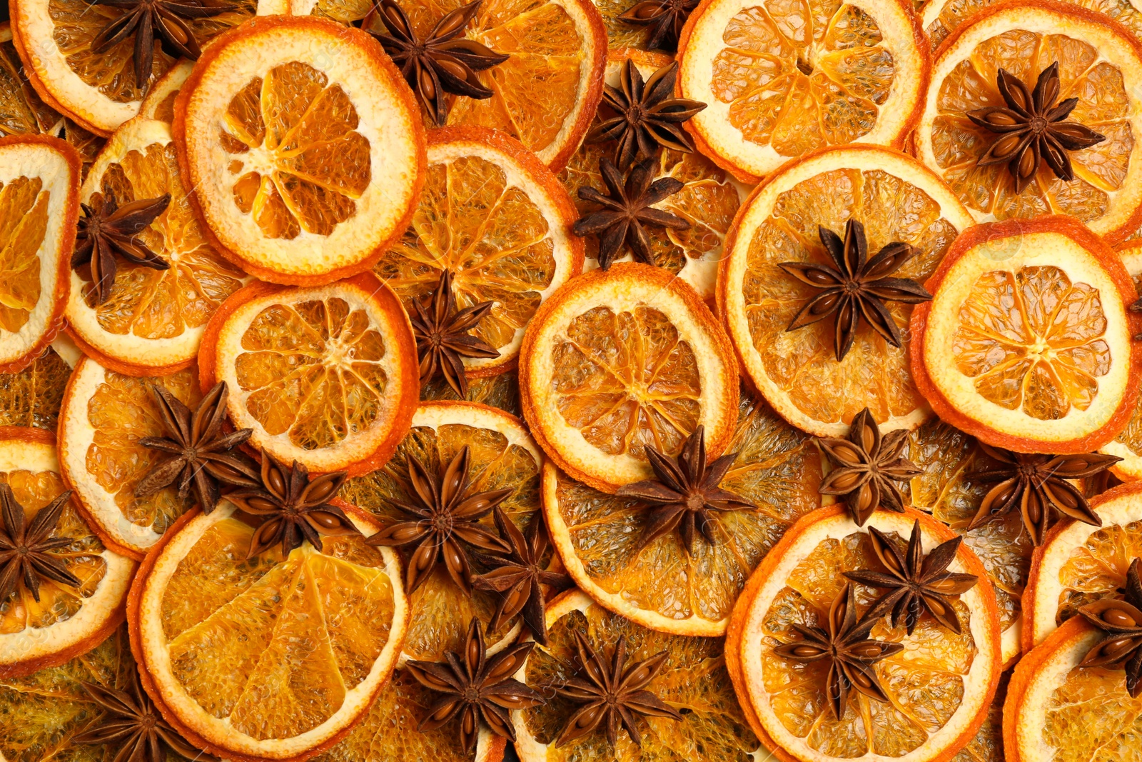 Photo of Dry orange slices and anise stars as background, top view